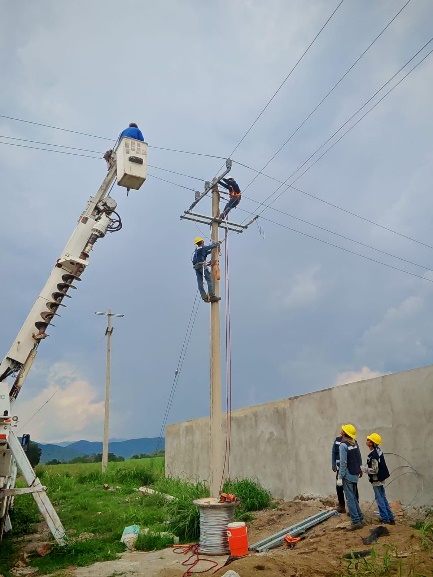 GE Solutions crew working on an overhead power line with support from a crane