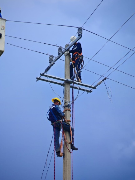 Technicians installing overhead electrical lines